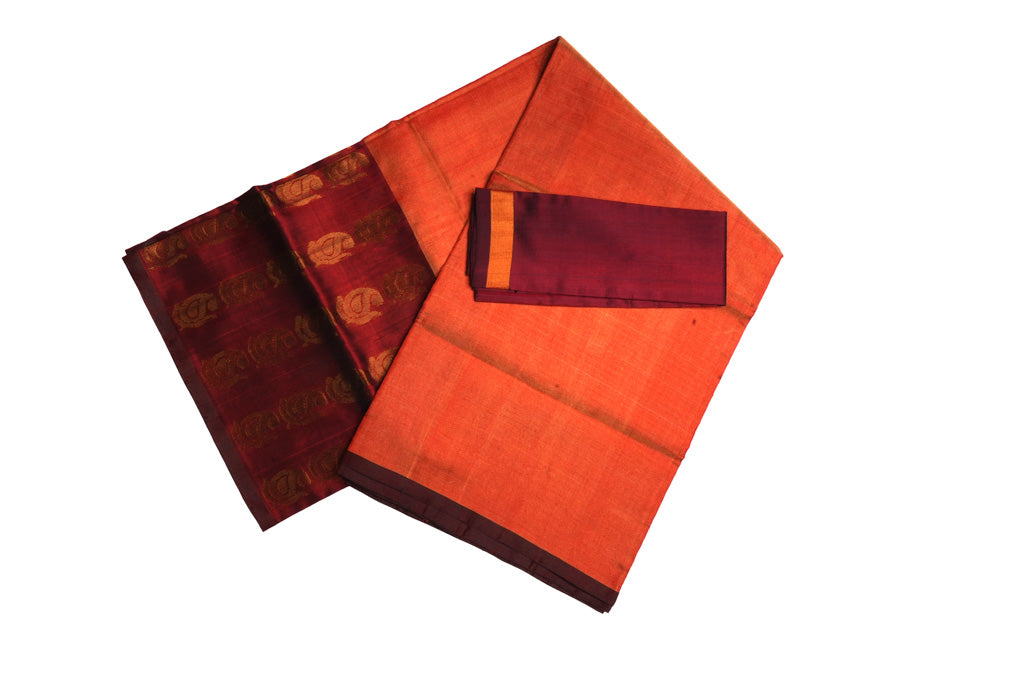 Folded orange Uppada Pattu saree showing maroon zari border and pallu