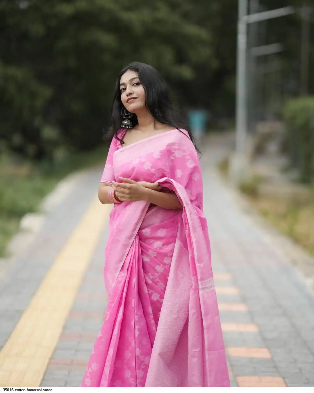 Model wearing a pink cotton Banarasi saree with floral motifs and matching pallu